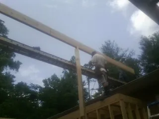 Carpenter setting a ridge beam over a new addition frame — Ice Dam Removal by Roofing Brothers in Cyril