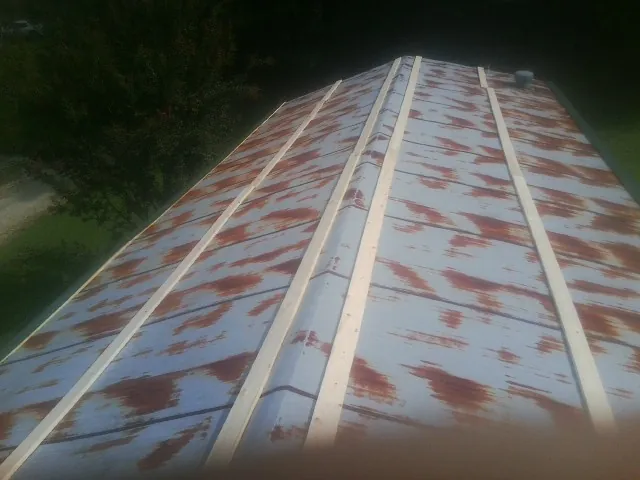 Rusted metal roof panels with new wood purlins before replacement — Storm Damage Roof Repair in Cyril by Roofing Brothers