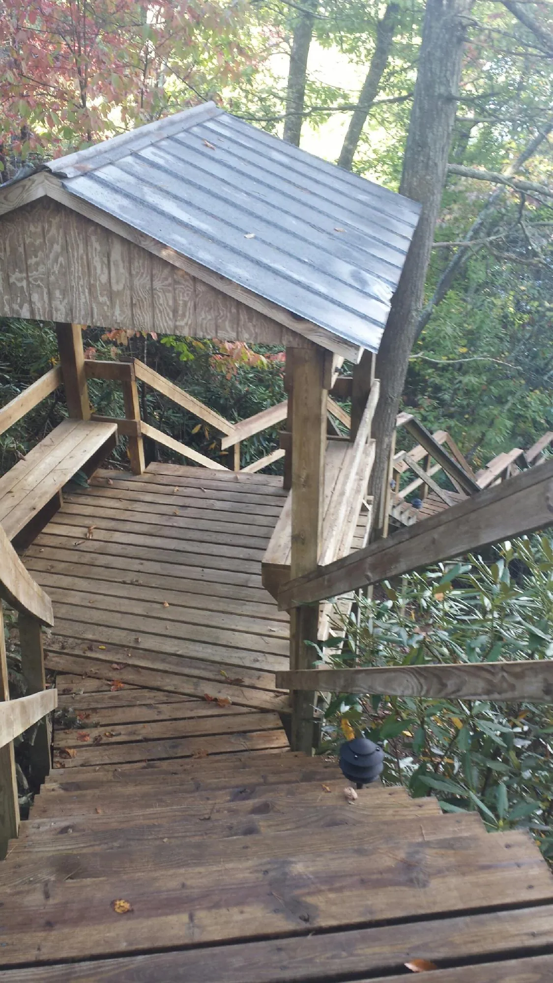 Metal roofed shelter over wooden steps on a wooded walkway — Skylight Repair & Installation work by our crew in Cyril
