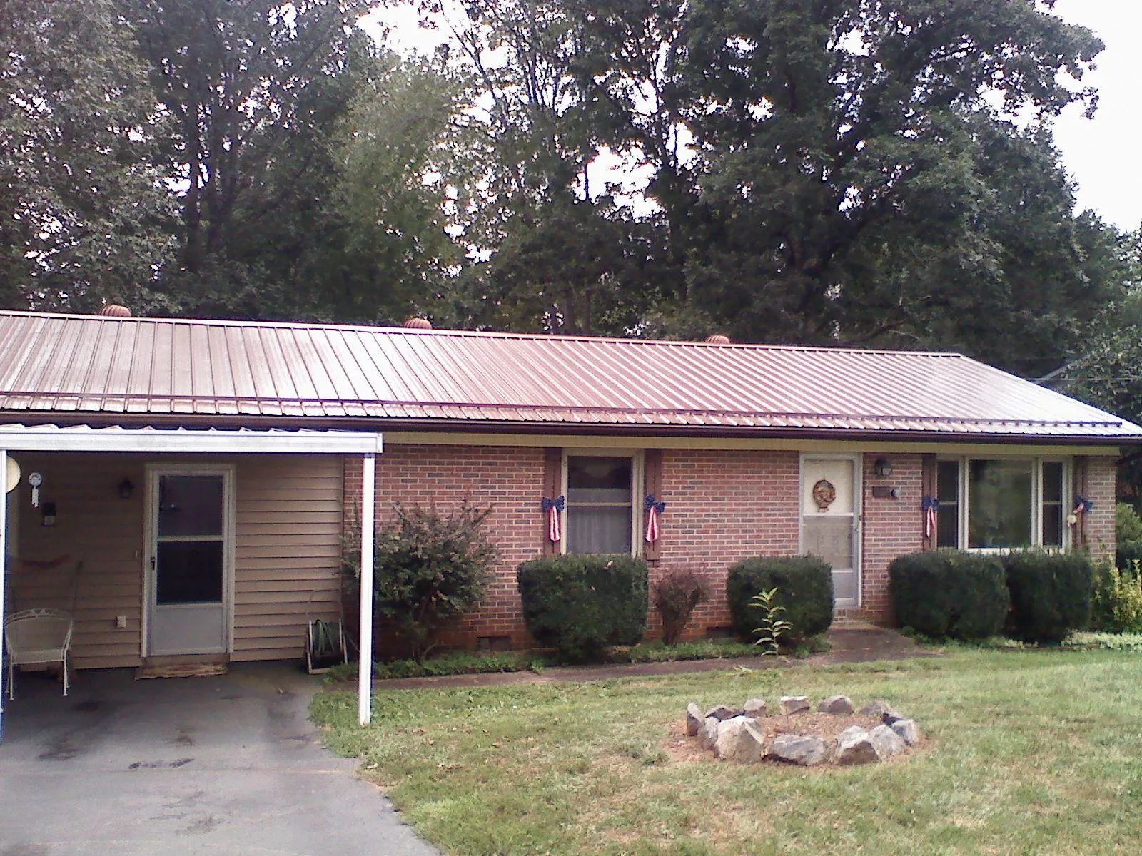 Bronze metal roof and carport on a brick ranch home — Roof Repair work by our crew in Cyril