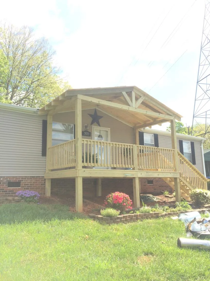 New gabled porch roof and deck railing added to a ranch home in Cyril